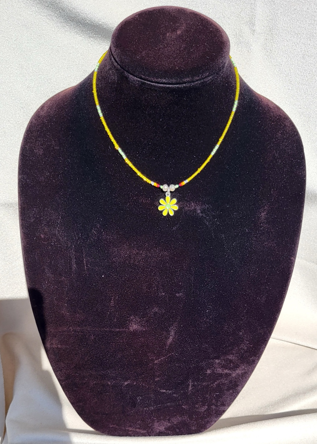 Bright yellow seed bead necklace with a yellow enamel daisy pendant