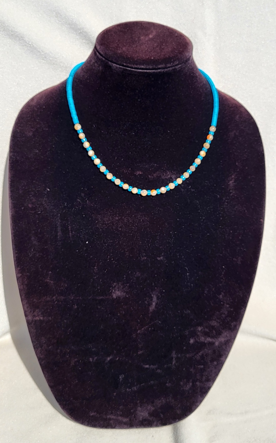 Turquoise heishi necklace with cream shell rounds through the centre