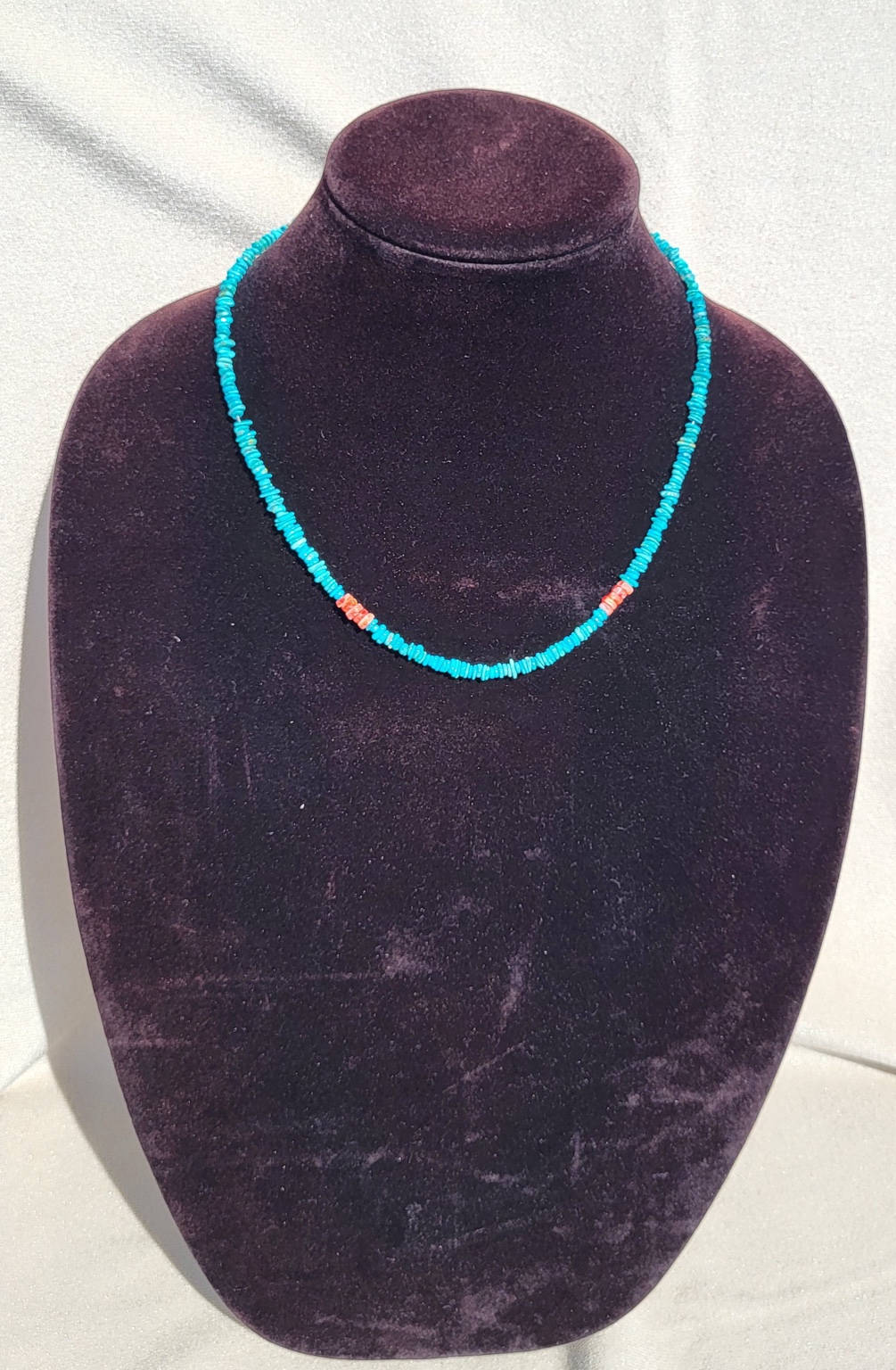 Turquoise chip bead necklace with a run of orange coral at the centre