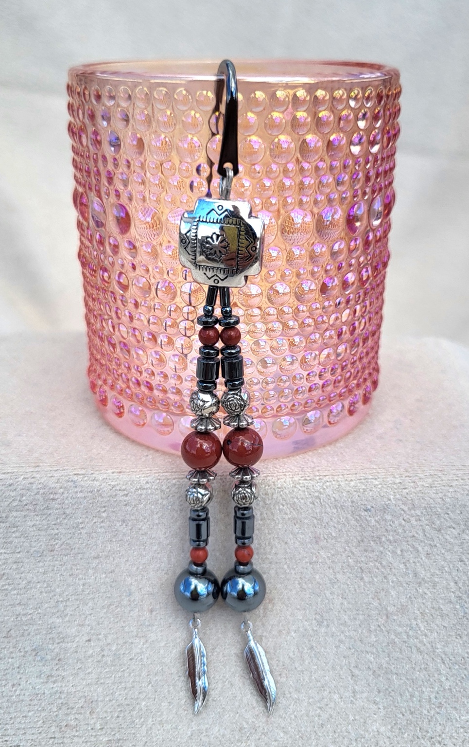 Long beaded earrings with stamped silver tops, red jasper beads and feather charms