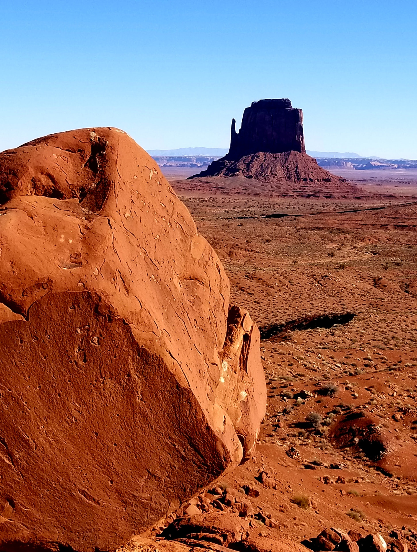 Sandstone boulder above the desert floor in low sunlight