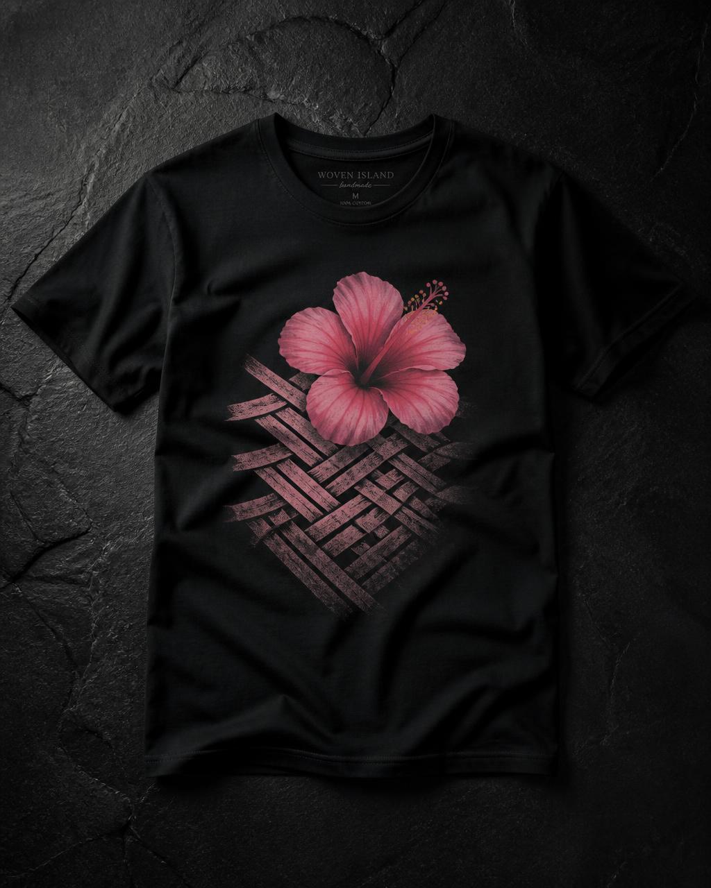 Black cotton tee printed with a pink hibiscus and woven pattern graphic